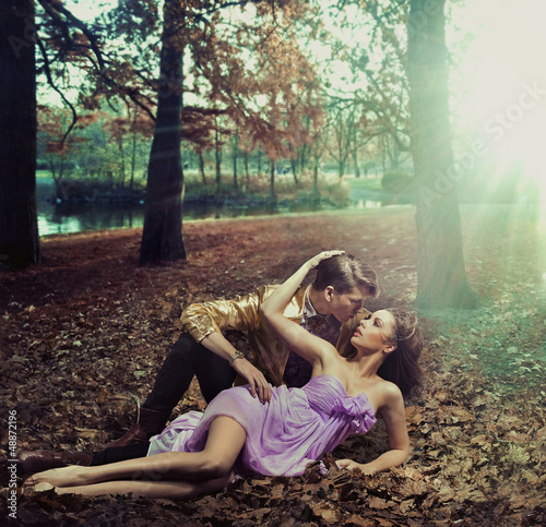 Photo: A loving couple lying on autumn leaves A loving couple lying on autumn leaves