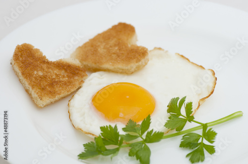 Photo: Fried egg with heart-shaped toasts for romantic breakfast Fried egg with heart-shaped toasts for romantic breakfast