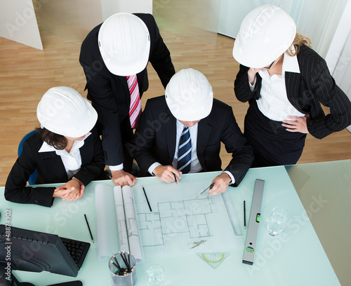 Photo: Architects discussing a blueprint Architects discussing a blueprint
