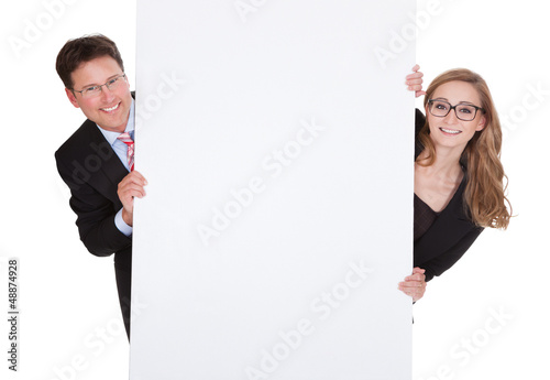 Photo: Professional man and woman with a blank sign Professional man and woman with a blank sign