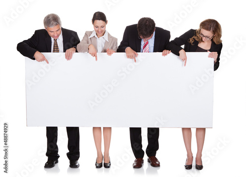 Photo: Businesspeople holding a blank banner Businesspeople holding a blank banner