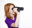 Teen red-haired girl with binoculars isolated on white backgroun