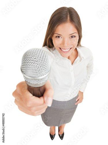 Photo: Smiling woman offering up a microphone Smiling woman offering up a microphone