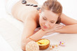 brunette woman receiving spa stones therapy