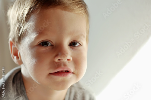Photo: on a light background portrait of smiling boy on a light background portrait of smiling boy