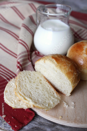 Photo: Milk buns bread with a milk pot on a kitchen towel Milk buns bread with a milk pot on a kitchen towel