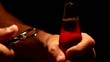 mani di uomo apre (stappa) bibita di vetro al buio
