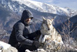 Photo: Man with dog hike in winter mountains Man with dog hike in winter mountains