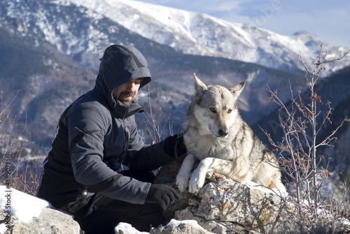 Photo: Man with dog hike in winter mountains Man with dog hike in winter mountains