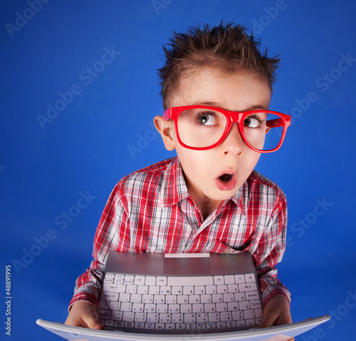 Photo: Little boy with a laptop, computer addiction concept Little boy with a laptop, computer addiction concept