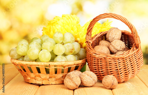 Photo: Grape in basket with nuts on wooden table Grape in basket with nuts on wooden table