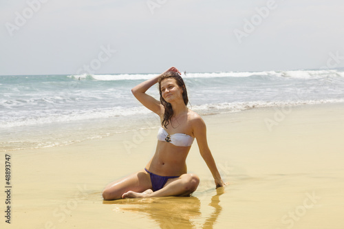 Photo: beautiful girl sunbathes on an ocean coast beautiful girl sunbathes on an ocean coast