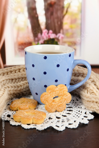 Photo: cup of tea with scarf on table in room cup of tea with scarf on table in room