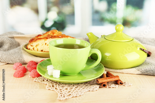 Photo: cup of tea with scarf on table in room cup of tea with scarf on table in room