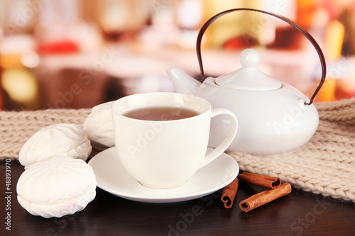 Photo: cup of tea with scarf on table in room cup of tea with scarf on table in room