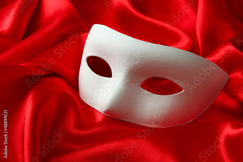 Photo: White mask, on red silk fabric White mask, on red silk fabric