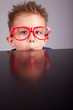 Photo: Five years old little cute boy hiding behind a table Five years old little cute boy hiding behind a table
