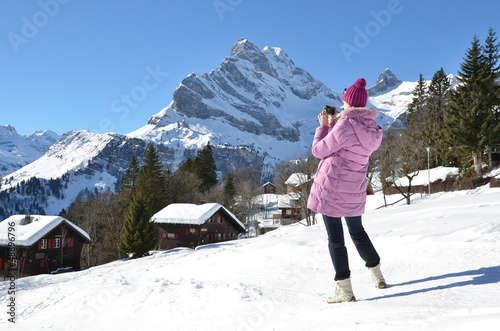 Photo: Girl taking a photo in Swiss Alps Girl taking a photo in Swiss Alps