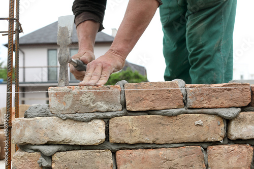 Photo: Mason making wall with mortar and bricks Mason making wall with mortar and bricks