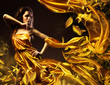 slim sexy woman in yellow fabric and leaves