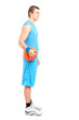 Full length portrait of a basketball player standing with a ball