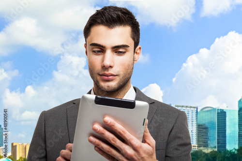 Photo: Business man holding his tablet Business man holding his tablet