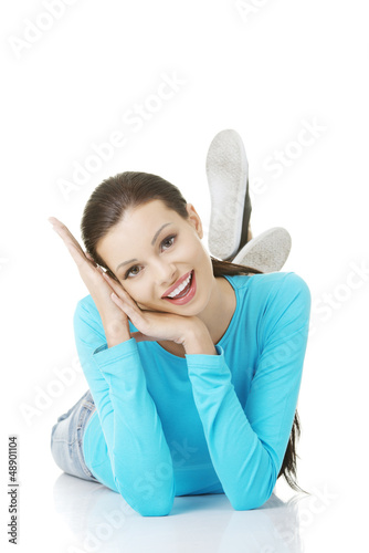 Photo: Happy woman in casual clothes lying on floor Happy woman in casual clothes lying on floor