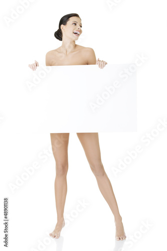 Photo: Sexy naked brunette holding empty board Sexy naked brunette holding empty board