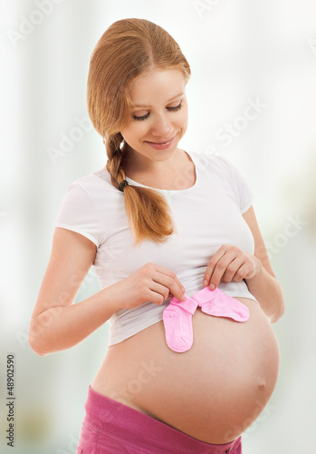 Photo: pregnant woman with blue pink baby socks pregnant woman with blue pink baby socks