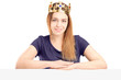 Foto: A beautiful queen with a golden crown posing behind a blank pane A beautiful queen with a golden crown posing behind a blank pane