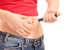 Young female injecting insulin in her abdomen