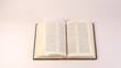 Bible (uncopyrighted book) lies on white table, pages are looked