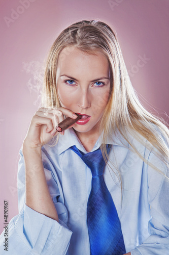 Photo: Cute woman smoking a cigar dressed with tie and shirt Cute woman smoking a cigar dressed with tie and shirt