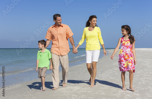 Photo: Mother, Father and Children Family Walking On Beach Mother, Father and Children Family Walking On Beach