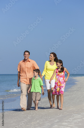 Photo: Mother, Father and Children Family Walking On Beach Mother, Father and Children Family Walking On Beach