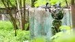 Video: Boy paintball player sits in ambush behind metal fence, then Boy paintball player sits in ambush behind metal fence, then