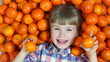 Girl orange. Happy child lying in oranges