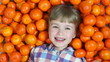 Happy baby girl hides in oranges