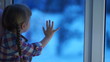Video: Child looking at playground winter. Snow falls on the street Child looking at playground winter. Snow falls on the street