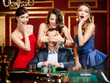 Photo: Girls cover the eyes of the gambler playing roulette Girls cover the eyes of the gambler playing roulette
