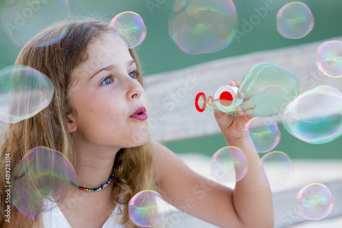 Photo: Summer joy - lovely girl blowing soap bubbles Summer joy - lovely girl blowing soap bubbles