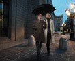 Elegant couple with umbrella outdoors on rainy evening