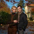 Elegant couple against country house on autumn day