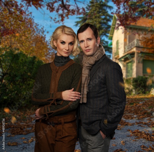 Photo: Elegant couple against country house on autumn day Elegant couple against country house on autumn day