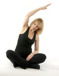 Mature, pretty  blond woman doing yoga stretching exercise
