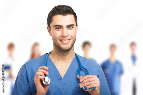 Photo: Handsome doctor in front of his team Handsome doctor in front of his team