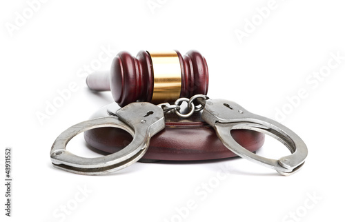 Photo: A pair of handcuffs and gavel A pair of handcuffs and gavel