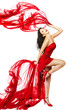 Photo: Woman in red dress dancing with fabric flying on a wind flow. Woman in red dress dancing with fabric flying on a wind flow.