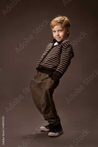 Photo: Happy Boy dancing over brown background. Vintage style. Happy Boy dancing over brown background. Vintage style.
