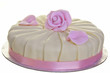 White and pink iced round cake isolated on white.